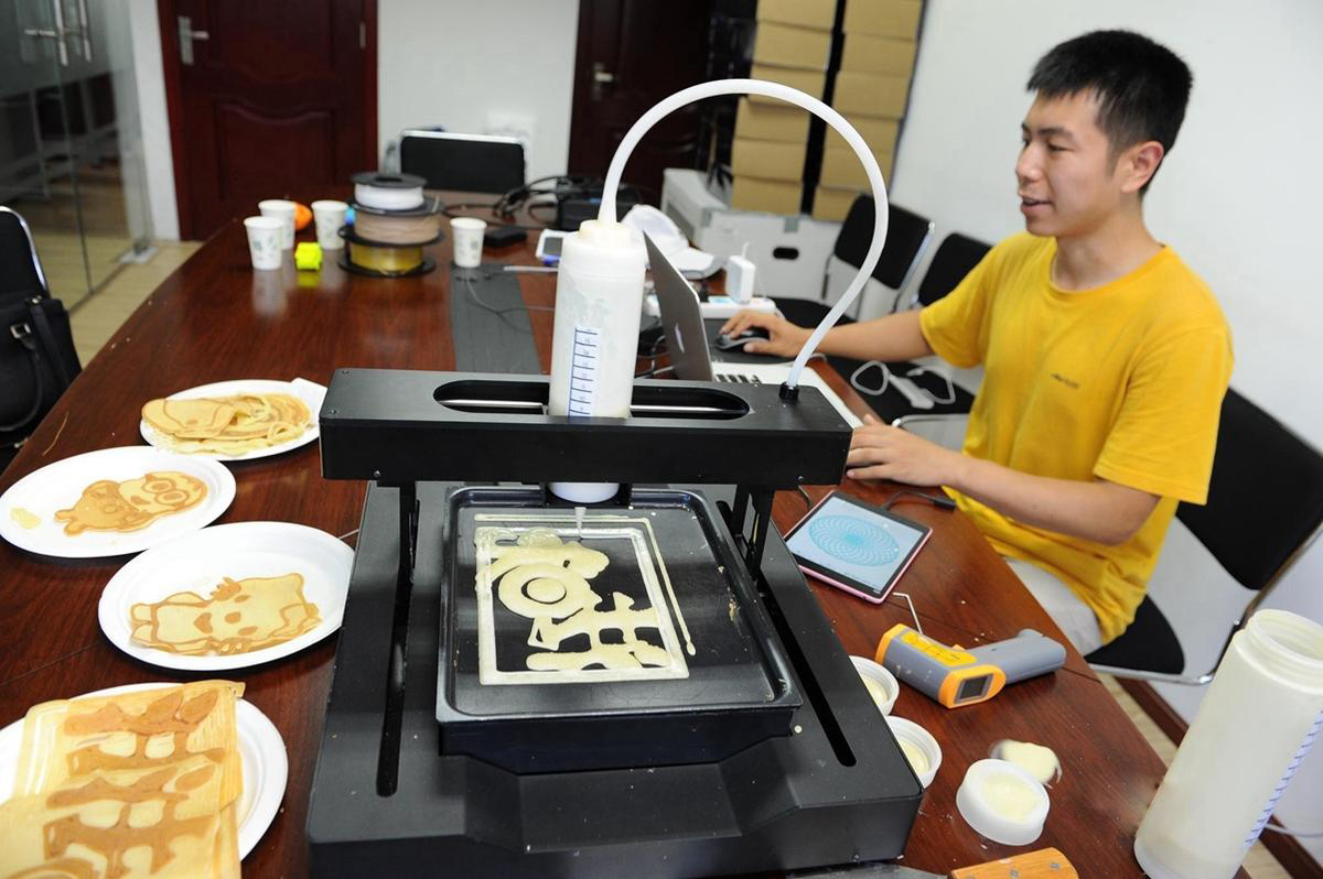 3D打印设备正在打印成型的各类人物煎饼